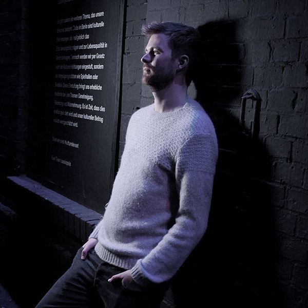 Michael, black and white portrait against a brick wall